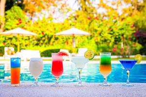 a group of wine glasses sitting on a table near a pool at Keur Saloum Resort in Toubakouta