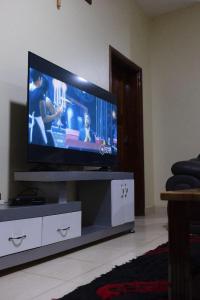 a flat screen tv sitting on a entertainment center in a living room at Green Hill Stay in Fort Portal