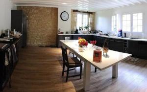 a large room with a table and a kitchen at la grange du coudert in Saint-Cybranet