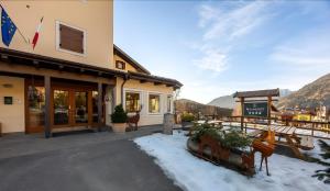 a hotel in the mountains with snow on the ground at Phi Hotel Bellamonte in Predazzo