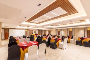 a banquet hall with red and yellow tables and chairs at S Hotels Chennai in Chennai