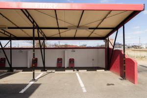 ein leerer Parkplatz mit zwei roten Parkuhren in der Unterkunft HOTEL Fiore Nakagawa -Adult Only- LOVE HOTEL in Nagoya