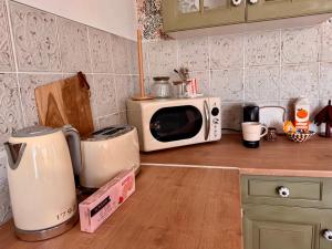 a kitchen counter with a microwave on top of it at La Romance in Acy-Romance