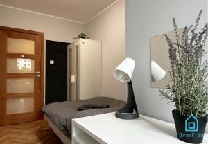 a bedroom with a bed and a lamp on a table at Elk Room - 5 Minutes to Sopot Molo & Seaside in Sopot