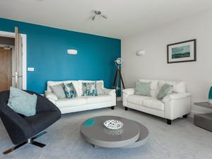 a living room with two couches and a blue wall at Jibe Ho - Beautiful Spacious Apartment with Harbour Views in Poole
