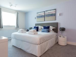 a bedroom with a large bed with towels on it at Jibe Ho - Beautiful Spacious Apartment with Harbour Views in Poole