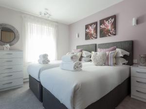 a bedroom with a large white bed with pillows at Jibe Ho - Beautiful Spacious Apartment with Harbour Views in Poole