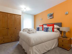 a bedroom with a large bed with orange walls at Jibe Ho - Beautiful Spacious Apartment with Harbour Views in Poole