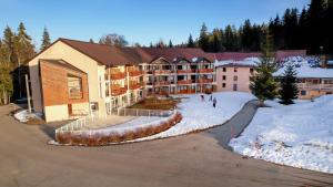 an apartment building with snow in front of it at VVF Jura Les Rousses in Prémanon