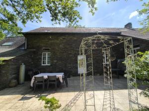 a patio with a table and chairs in front of a building at La Mérais in Marsac-sur-Don