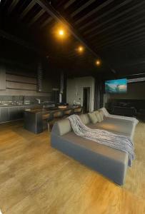 a large room with a couch and a kitchen at Loft Vilas Boas in Nova Lima