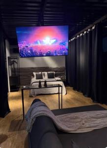 a bedroom with a large screen on the wall at Loft Vilas Boas in Nova Lima
