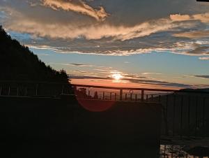 a sunset over a body of water with a fence at Amazing view Home Stay in McLeod Ganj