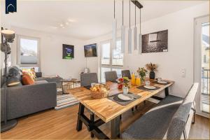 a dining room and living room with a wooden table at Ostseebude in Loddin