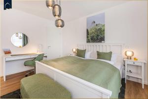 a bedroom with a bed and a desk and a mirror at Ostseebude in Loddin