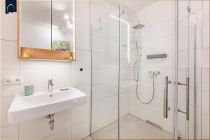 a white bathroom with a sink and a shower at Ostseebude in Loddin +35 photos