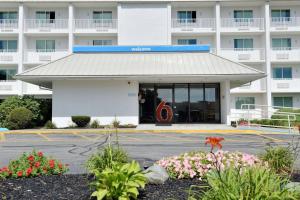 a hotel building with a parking lot with flowers at Motel 6-Danvers, MA - Boston North in Danvers