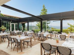 a restaurant with tables and chairs and windows at Hotel Palacio Urgoiti in Mungia