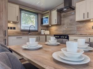 a kitchen with a wooden table with dishes on it at Oakmont Lodge in Allerthorpe