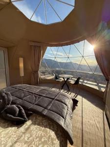 a bedroom with a bed and a large window at Le dôme de Jèpo in Ilonse