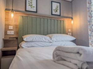 a bedroom with two beds and a green headboard at Oakmont Lodge in Allerthorpe