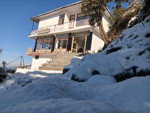 a house in the snow with snow around it at Amazing view Home Stay in McLeod Ganj
