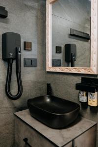 a bathroom with a black sink and a mirror at Tatrowisko Zakopane Domki Góralskie in Zakopane +29 photos