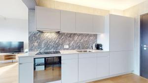 a kitchen with white cabinets and a sink at Alto-Tower Residence - Self Check In in Zurich +7 photos