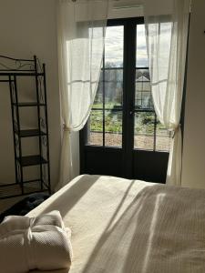 a bedroom with a bed and a large window at Ker Loal in Romazy