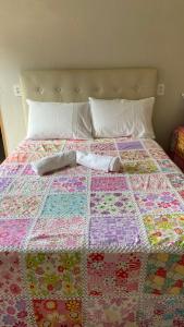 a quilt laying on top of a bed at Flat casa de madeira in São José da Coroa Grande