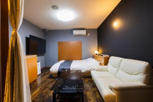 ein Wohnzimmer mit Sofa und Bett in der Unterkunft HOTEL Fiore Nakagawa -Adult Only- LOVE HOTEL in Nagoya