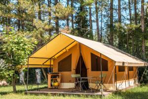 a yellow tent with a table and chairs in it at Camping Onlycamp la Rochette in Guillestre