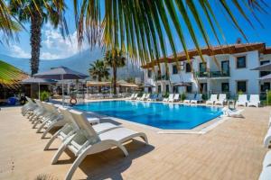 a swimming pool with lounge chairs and a hotel at Fethiye Park Hotel in Fethiye