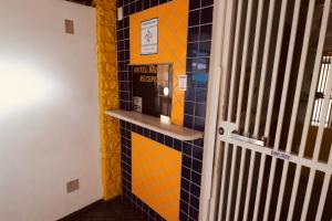 a bathroom with a pay phone on a tile wall at Hotel Bellamy in São Paulo