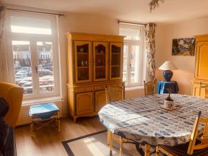 a dining room with a table and a cabinet at Au Cœur d Etaples in Étaples