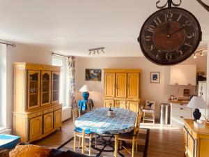 a dining room with a table and a large clock on the wall at Au Cœur d Etaples in Étaples