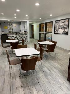 a waiting area with tables and chairs in a waiting room at Super 8 by Wyndham Lincoln in Lincoln