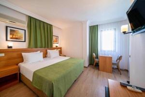 a hotel room with a bed and a television at Fethiye Park Hotel in Fethiye