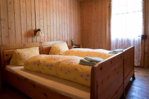 a bedroom with a bed with yellow sheets and a window at Berggasthaus Voralp in Grabs