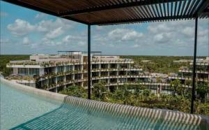 a resort swimming pool with a view of a building at Alof Studio in the Jungle in Tulum