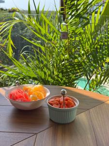 two bowls of fruit sitting on a wooden table at Alof Studio in the Jungle in Tulum