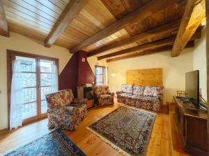a living room with two chairs and a television at Hostdomus - Flower Loft in Cesana Torinese