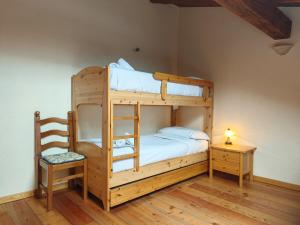 a bedroom with two bunk beds and a chair at Hostdomus - Flower Loft in Cesana Torinese
