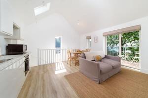 a living room with a couch and a kitchen and a table at Tree Top - Perfect Apartment For Relaxing Getaway, Balcony, Parking in Lynmouth