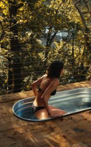 a woman in a bikini sitting in a hot tub at Tree Top - Perfect Apartment For Relaxing Getaway, Balcony, Parking in Lynmouth