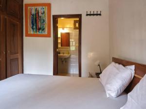 a bedroom with a white bed and a bathroom at Case Africaine Confort Terrasse Accès Plage in Mbour +48 photos