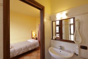 a bathroom with a sink and a mirror and a bed at Hotel Locanda dell'Oca Bianca in Como +50 photos