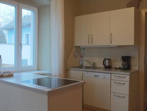 a kitchen with white cabinets and a sink and a window at Ferienwohnung Veit in Aigen im Mühlkreis