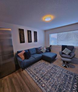 a living room with a blue couch and a chair at Atare Suite in Saskatoon