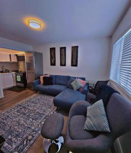 a living room with a blue couch and chairs at Atare Suite in Saskatoon